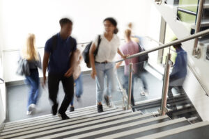 High School Students Walking On Stairs Between Lessons In Busy College Building