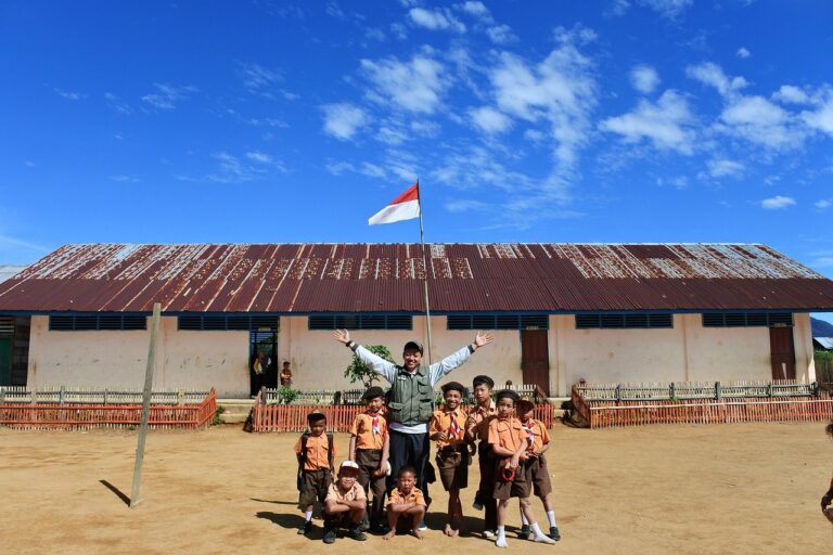 Happy high school student with teacher balancing extracurricular activities at school